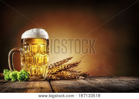 Oktoberfest beer with wheat  and hops on wooden table