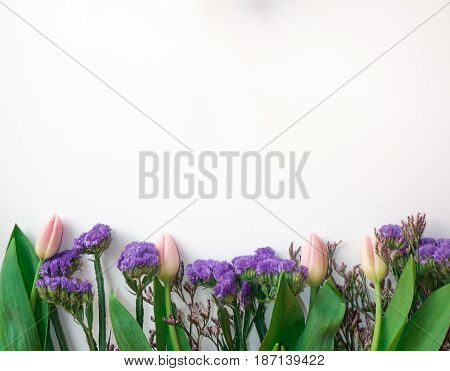 Present cart on white bakground with violet and pink tulips