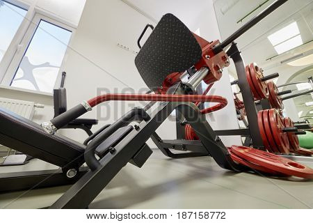 Leg press training machine in gym room.