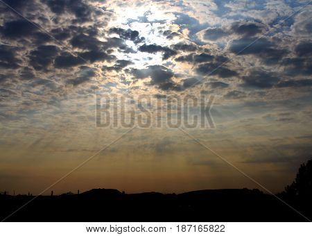 Sunlight between clouds in a sunset sky