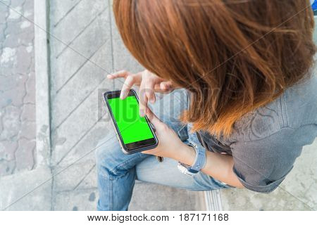 Beautiful girl holding a smartphone in the hands of a green screen green screen hand of man holding mobile smart phone with chroma key green screen on white background new technology concept