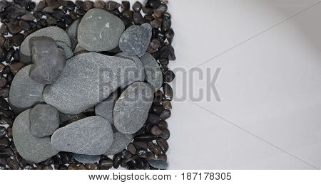 Stacked Rocks on a white background with color rocks on top