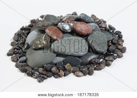 Stacked Rocks on a white background with color rocks on top