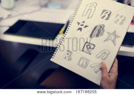 Hand Holding Notebook With Drew Brand Logo Creative Design Ideas