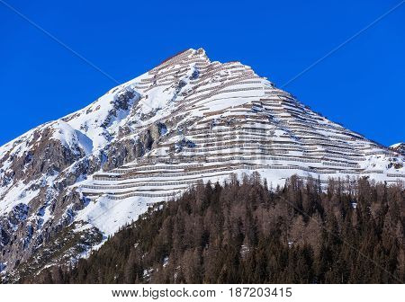 Summit of the Schiahorn mountain with snow fences for avalanche control, as seen from the town of Davos in the Swiss canton of Grisons in wintertime.