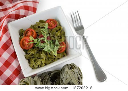 Close up of pasta in bowl by napkin on white background