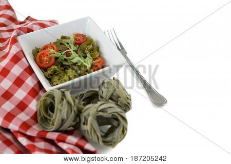 High angle view of pasta in bowl by napkin on white background