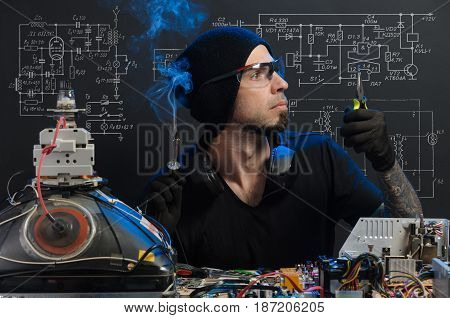 the man is engaged in repair of electronics
