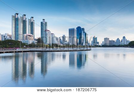 Twiligh tone City office building with water reflection in public park Bangkok Thailand