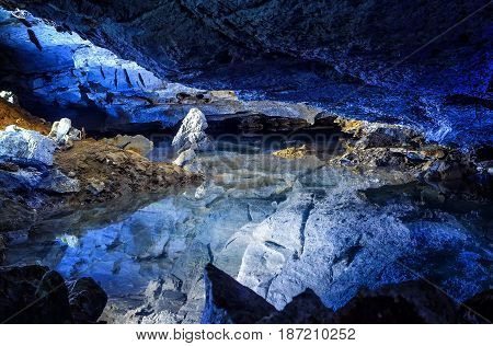 the slope of the mountain with the reflection in the water inside a fantastic cave. Kungur In The Urals