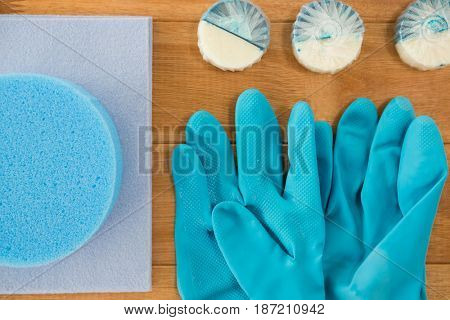 Overhead v iew of glovers by sponge and wide pads on wooden table