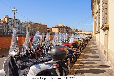 Parking mopeds on Lungarno Generale Diaz an embankment along the Arno river - Florence Tuscany Italy, 11 October 2011