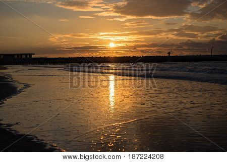 Sunset at the pier at the North Sea beach of Cadzand Holland