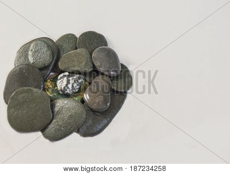 Pile of rocks with a black and white one on top