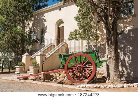 An historic horse or ox drawn cart in front of the historic station building in Matjiesfontein now a museum