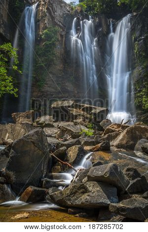 Waterfalls in Costa Rica with brown and grey rocks and green flora
