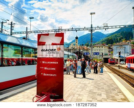 CHUR, SWITZERLAND, AUG, 20, 2010: View on Glacier Express panoramic mountain train advertising banner on Swiss rail way station, red mountain passenger train. Swiss holidays vacations travel tours
