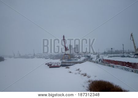 Gantry crane at the dock. Winter. Cloudy sky.