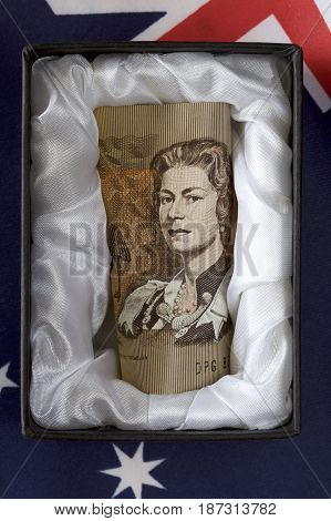 Discontinued Australia one dollar note in a coffin with Australian flag.