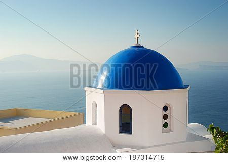 Iconic blue domed church of Santorini Greece overlooking the caldera