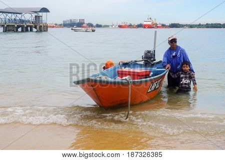 Labuan,Malaysia-Feb 19,2017:Traditional fisherman with fishing boat in beach of Papan island at Labuan Pearl of Borneo,Malaysia.