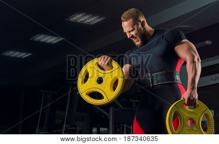 Professional athlete in bench equipment makes a hand bend with a rod disc