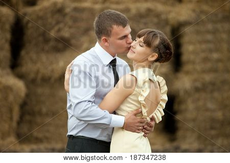 Man Kisses Lady In A Cheek Hugging Her Betwenn Haycocks