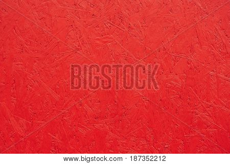 Red painted wood chipboard texture background. Close up