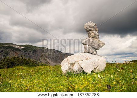 Mountains and balancing stones on the green meadow