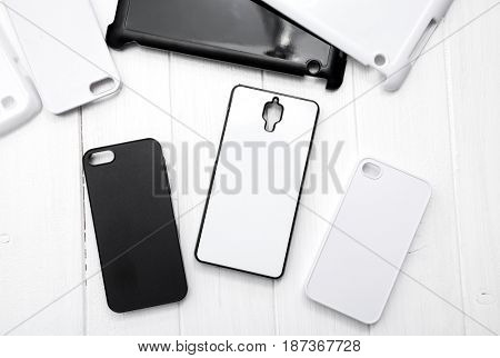 Different monochrome black and white cases for cellphones on the table, topshot