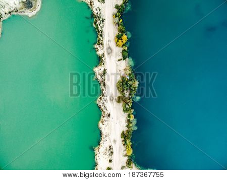 Aerial view - narrow strip of sandy shore and green and blue water, top view