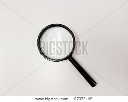 Magnifying glass isolated on white vackground reflected ceiling electronic light