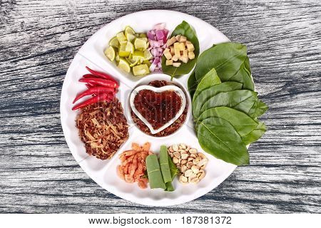 Thailand Vietnamese dessert Leaf wrapped bite size appetizer grated coconut ginger shallots peanuts dried shrimps lime chillies and edible tree leaves Call Miang Kum in Thai