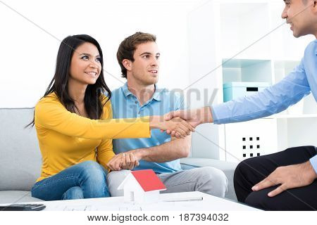 Young couple meeting with real estate agent (or financial adviser) at home