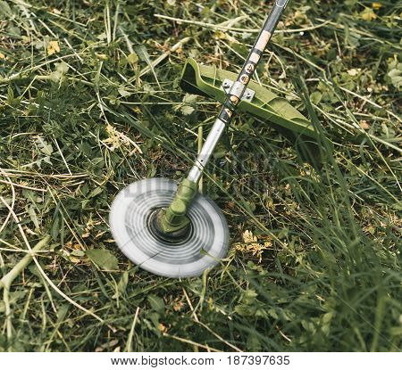 Gasoline Trimmer Head On Green Grass. Round Trimmer Blade.