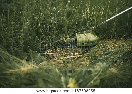 Gasoline Trimmer Head On Green Grass. Round Trimmer Blade.