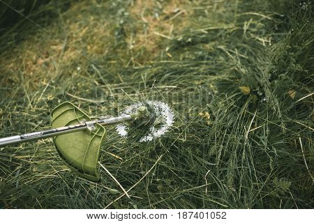 Gasoline Trimmer Head On Green Grass. Round Trimmer Blade.