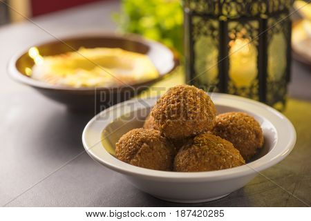Close up of Falafel and hummus, an authentic arabic cuisine, arranged along with Ramadan traditional lantern.