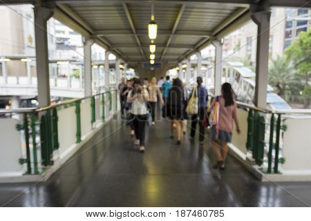 blurred background of unidentified people walk across at Asoke in Bangkok Thailand