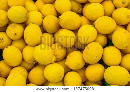 Bright ripe yellow lemons in supermarket background texture