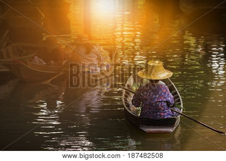 woman sailing thai trading boat in floating maket most popular traveling destination in dumnern sadauk canal ratchaburi thailand