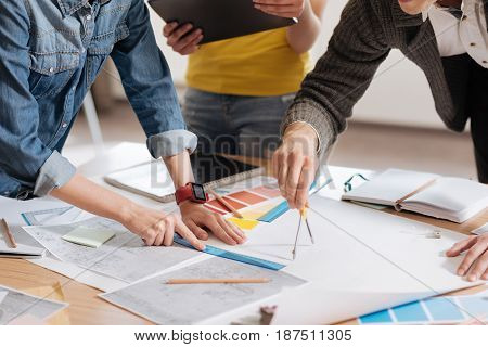 Future project. Close up of a pair of compasses being in use by a good looking handsome creative designer while drawing