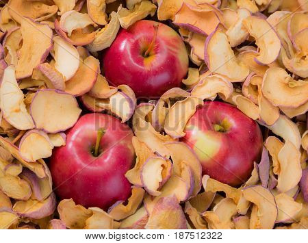 Three ripe red Apple in a pile of dried fruit