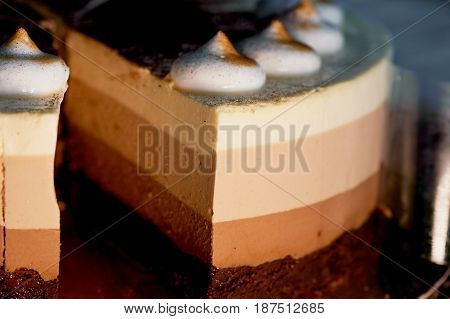 four layer cake with shades of brown. Here cream to chocolate.
