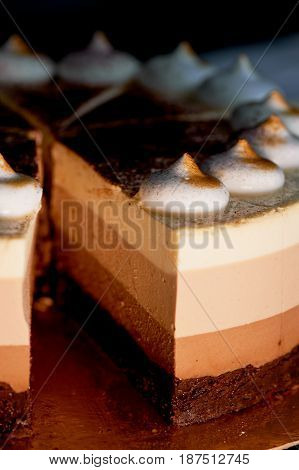 four layer cake with shades of brown. Here cream to chocolate.