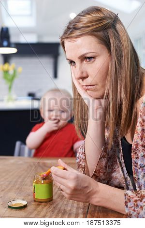 Stressed Mother Trying To Feed Fussy Baby
