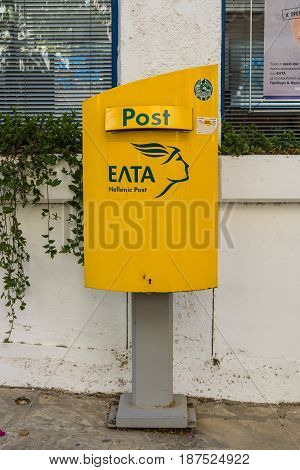CRETE GREECE - JULY 11 2016: The Postal Box of the State Postal Service (Hellenic Post) on a street in the coastal town of Agios Nikolaos.