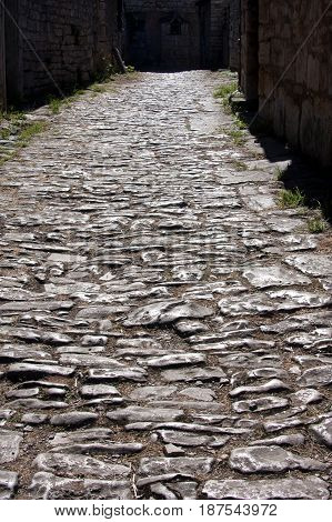 Narrow mediterranean street covered by stone on Solta island in Croatia