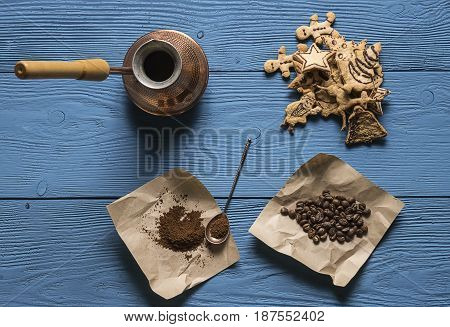 Coffee Beans, Ground Coffee, A Turk, A Silver Spoon For Kraft Paper And Christmas Cookies On The Blu