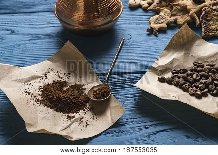 Coffee Beans, Ground Coffee, Silver Spoon On Kraft Paper And Christmas Cookies On The Blue Boards